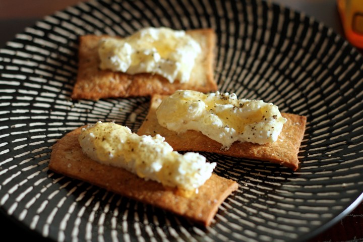 Crackers topped with homemade ricotta, honey and black pepper