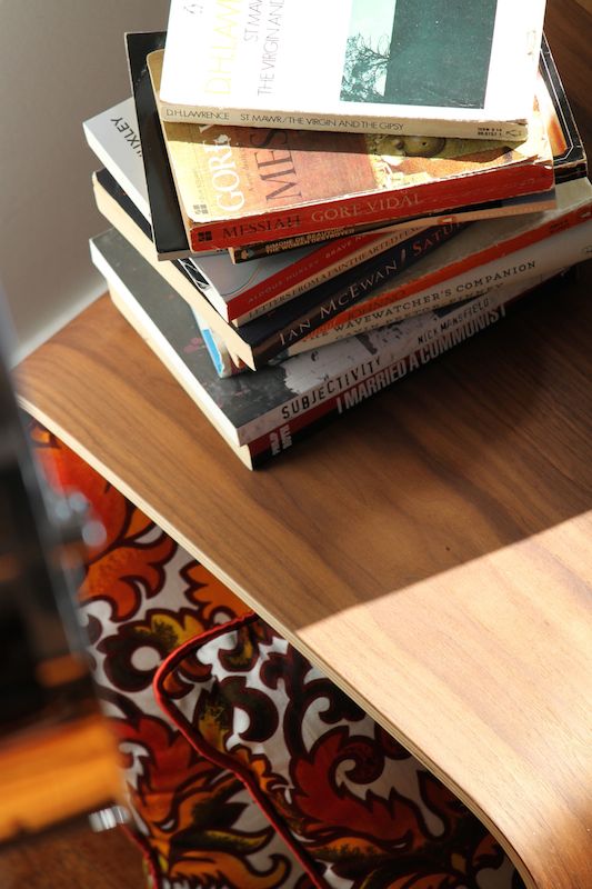 A pile of second hand books, Matt Blatt coffee table and retro cushions