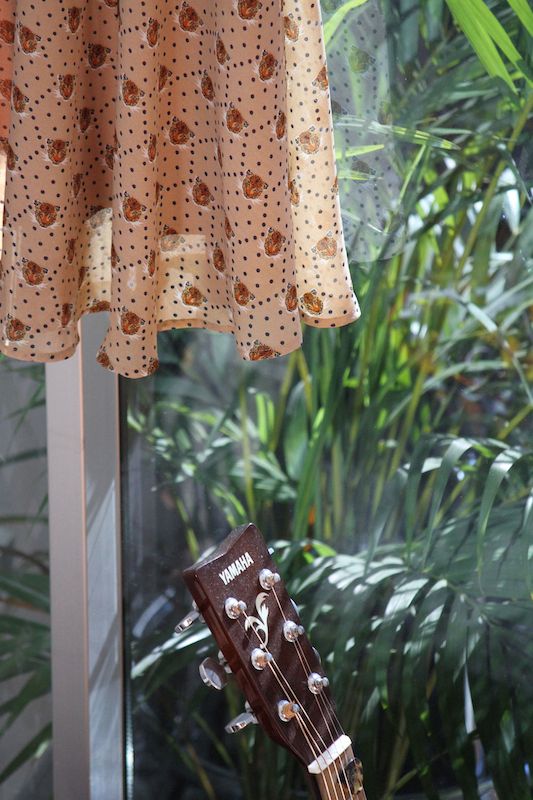 Cheetah dress and guitar, looking out onto the potted palms on the balcony