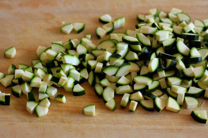 Courgettes (zucchini) are chopped into small dice to form the base of the soup