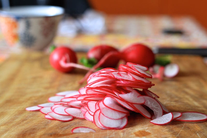Red radishes sliced using a mandolin, ready to make pickle